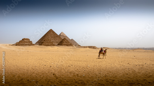 Riding camel under pyramid