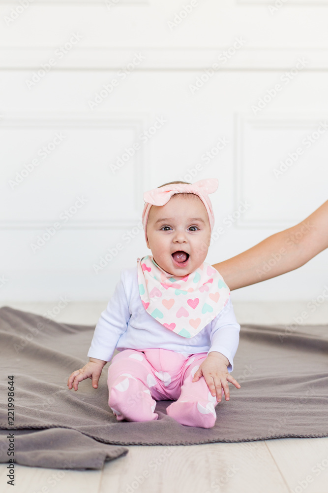Smiling Infant Baby 6 Month Old. Cute little girl in modern clothes. Happy baby looking at camera Smiling Infant Baby 6 Month Old. Cute little girl in modern clothes. Happy baby looking at camera