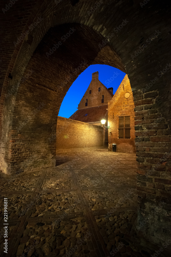 Obraz premium The entrance through an authentic monumental city gate to a characteristic medieval town. Remains of a historic old fortified town in the Netherlands 