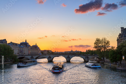 Beautiful vibrant sunset over the river Seine in Paris, France, with a tourist c Fototapet