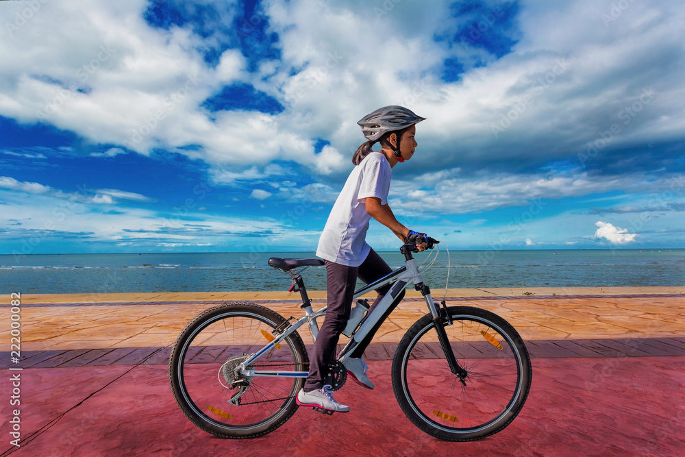 Fototapeta premium Girl cycling at beach on daylight