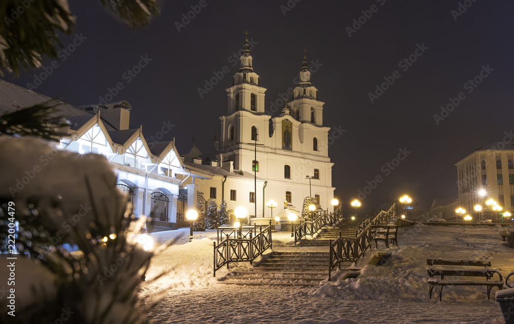 Fototapeta premium Winter Minsk at night. Christmas in Minsk, Belarus. Cityscape of Belarus capital. Famous church orthodox tower in center of city. Xmas background. New Year time in December at Minsk.