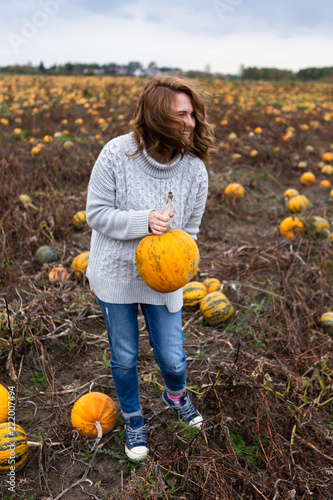 Woman with a pumpkin on a pumpkin field