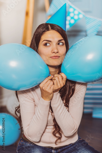 Ladys fun. Glad adorable woman monkeying with balloons while smiling to camera