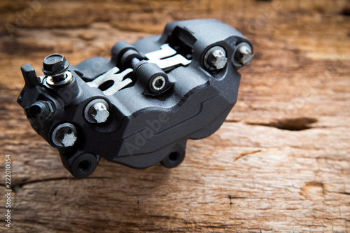 Close up photo of Caliper brake system for big bike on old wood background