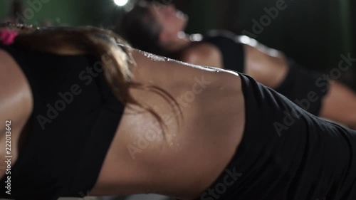 Women sweaty tummy in low key lighting yoga studio rapid slow motion