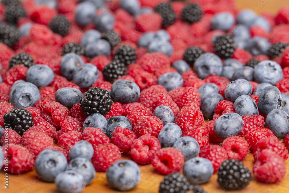 Raspberry, BlackBerry and blueberry on wooden background