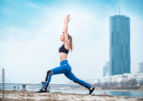 Woman exercising, blurred city in background