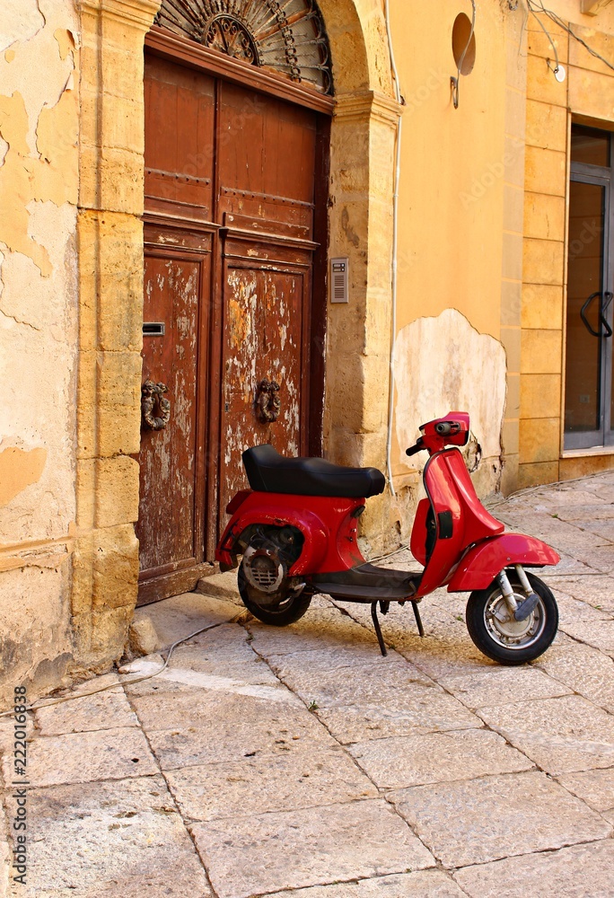 Italy: Old scooter in front old doorway.