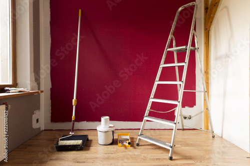 Tools for coloring, paint roller, brush, aluminium leader. Wall partly collored.