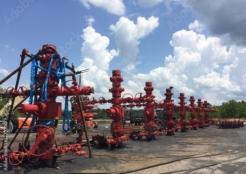 Bright Red Frac Stack at Hydraulic Fracturing Site Against Big Blue Sky photo