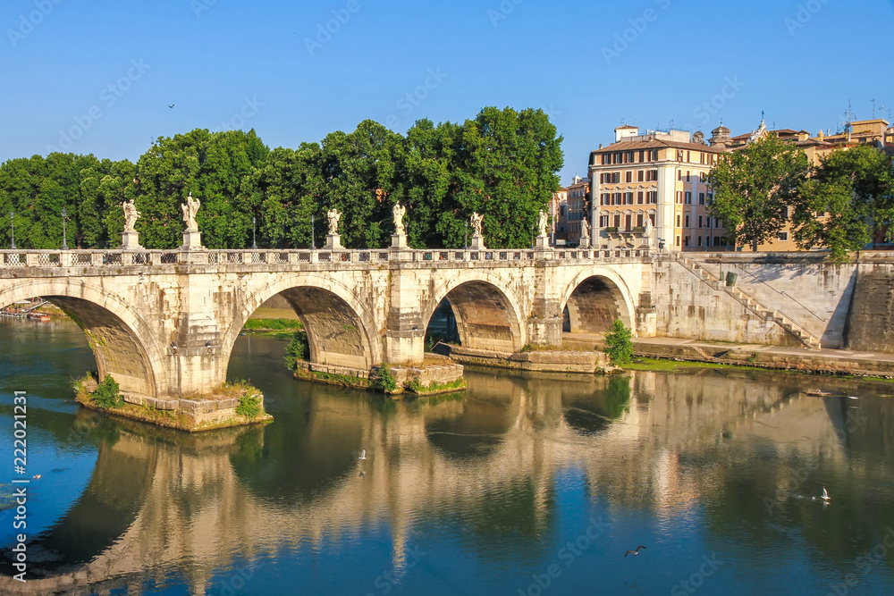 View on the Sant Angelo bridge over the Tiber river in Rome, Italy on a sunny day.
