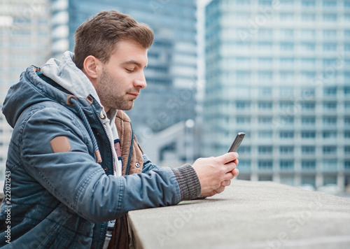 Profile or side view of guy with phone. Man using smartphone
