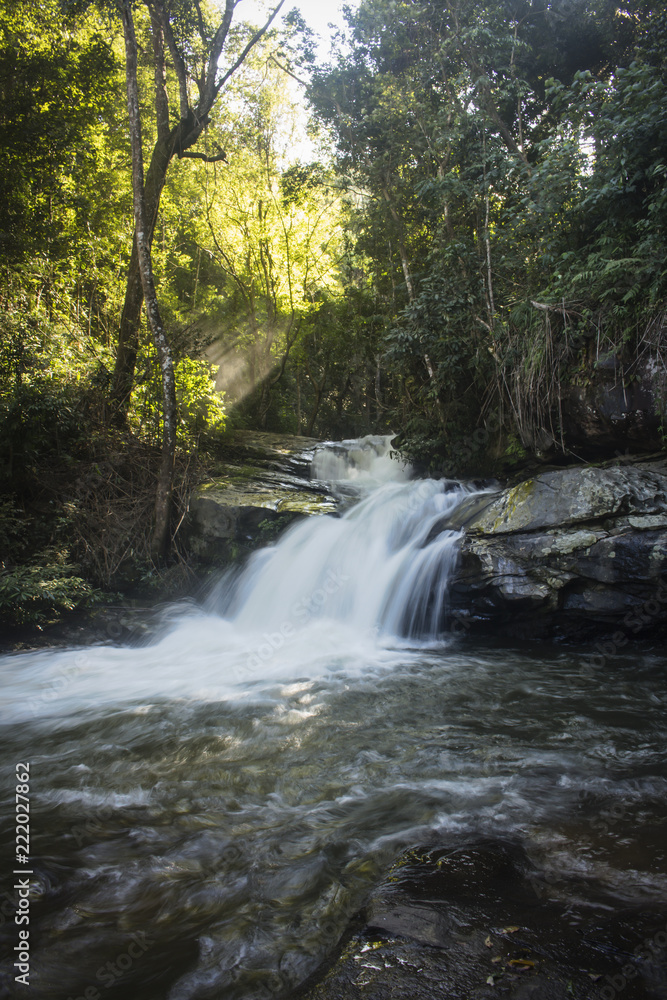 Small waterfall found in the beautiful forest of Mae Klang Luang. Chiang Mai, Thailand. Sun shining through the foliage. Small waterfall found in the beautiful forest of Mae Klang Luang. Chiang Mai, Thailand. Sun shining through the foliage.
