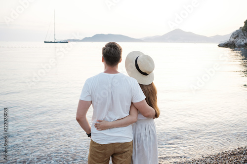 Back view of romantic couple at the beach and looking to the horizon. © Boyarkina Marina