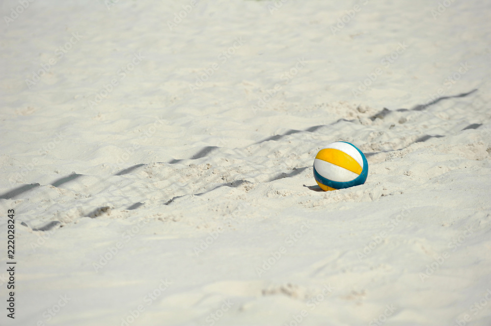yellow and darkblue volleyball ball on the sand