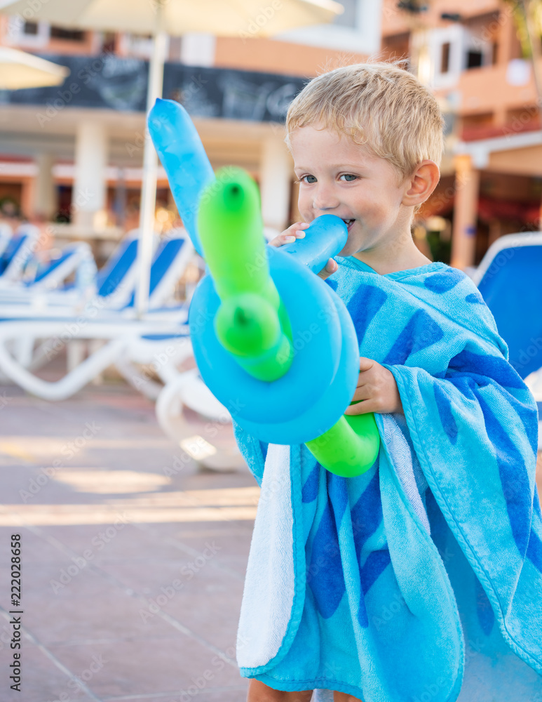 Φωτογραφία beautiful child plays with balloons at the edge of the pool, sunny day,close up
