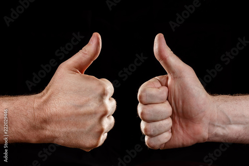 Two hands showing approval, on a black background