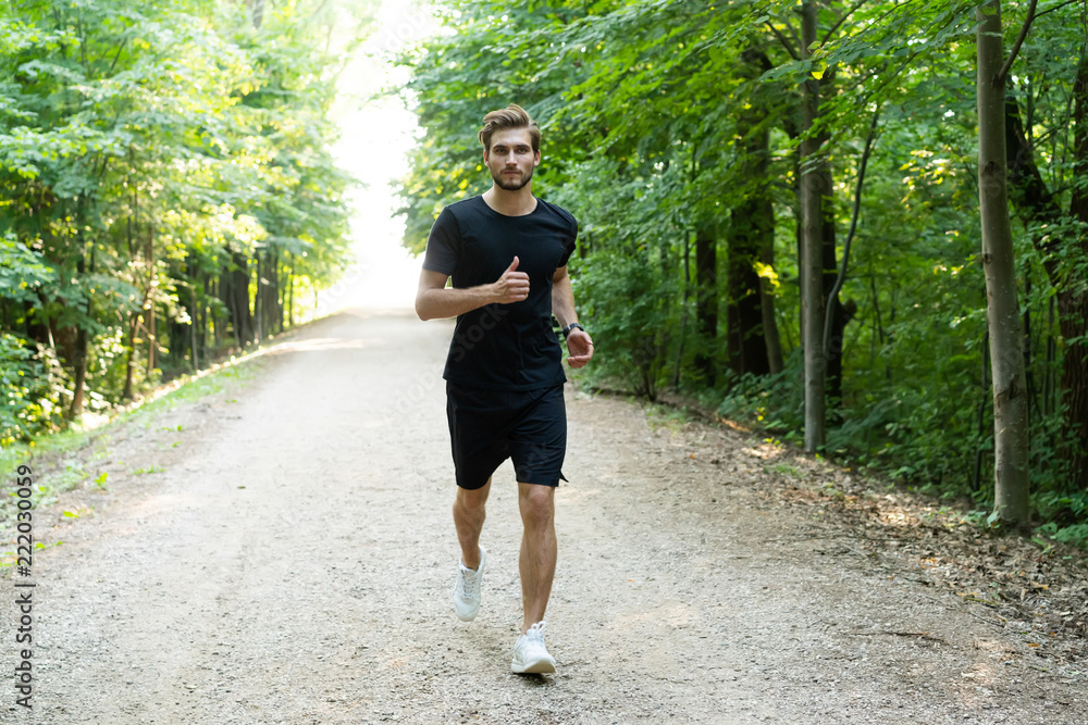 Athletic young man running in the nature. Healthy lifestyle