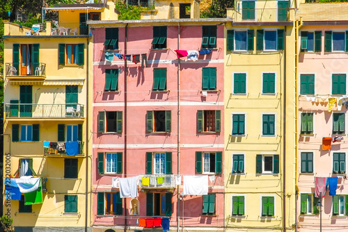 View on the beautiful colourful houses with clothes drying in the sunny daylight in Cique Terre, Italy.