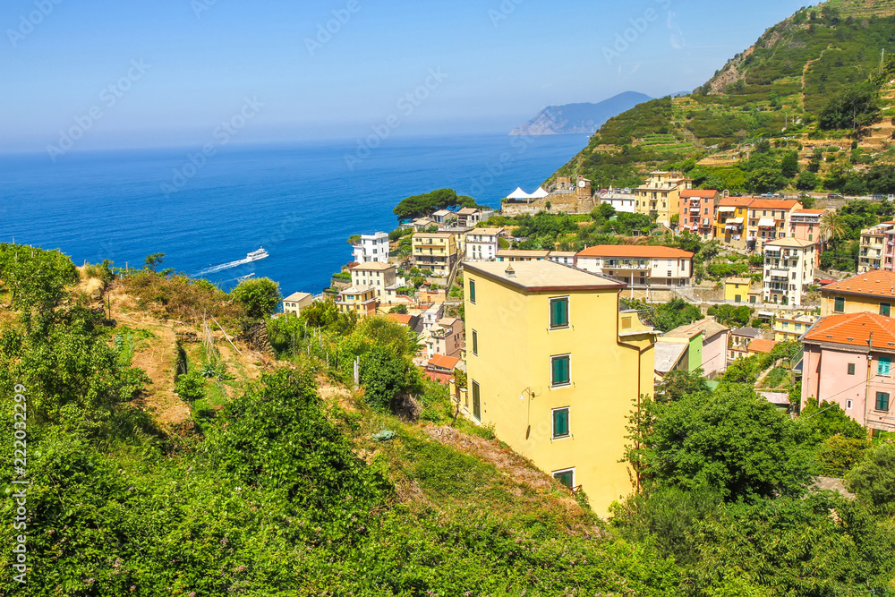 View over the the historic architecture of Cinque Terre, Italy with colourful houses on a sunny day.