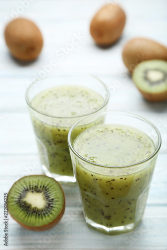 Fresh kiwi smoothie in glass on wooden table