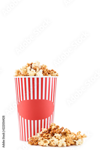 Caramel popcorn in striped bucket isolated on white background