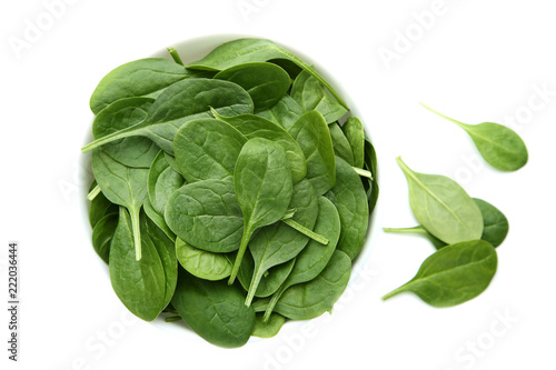 Spinach leafs in bowl isolated on white background