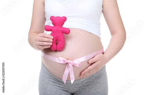 Pregnant woman with pink ribbon and toy on white background