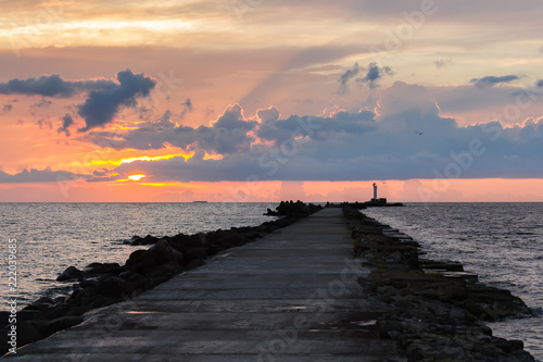 Lighthouse at the entrance to the port of Riga in the evening on sunset light, in summer