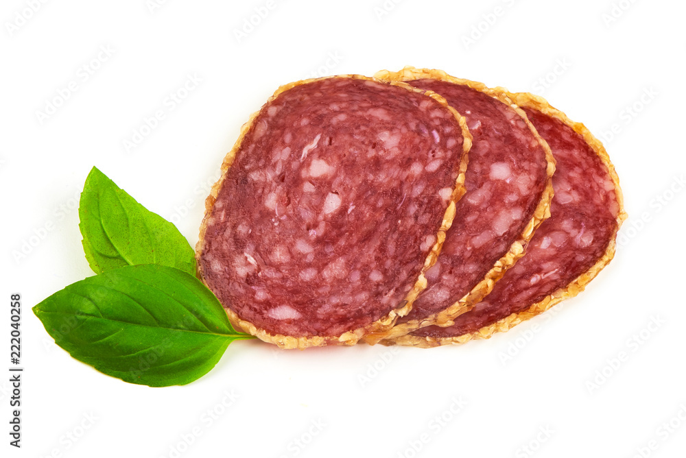 Obraz premium Smoked salami sausages slices with basil leaves, isolated on white background
