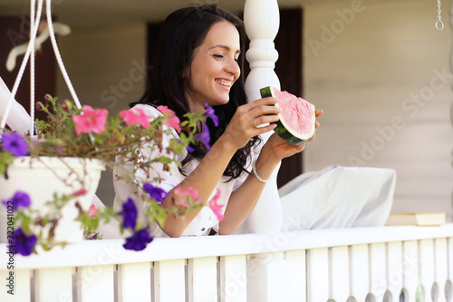 Girl on a wooden porch with watermelon