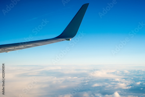 Wing of the plane on blue sky background © dima