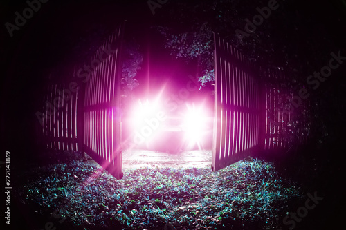 The car stands on the territory of the house at night. Light headlights through the fence