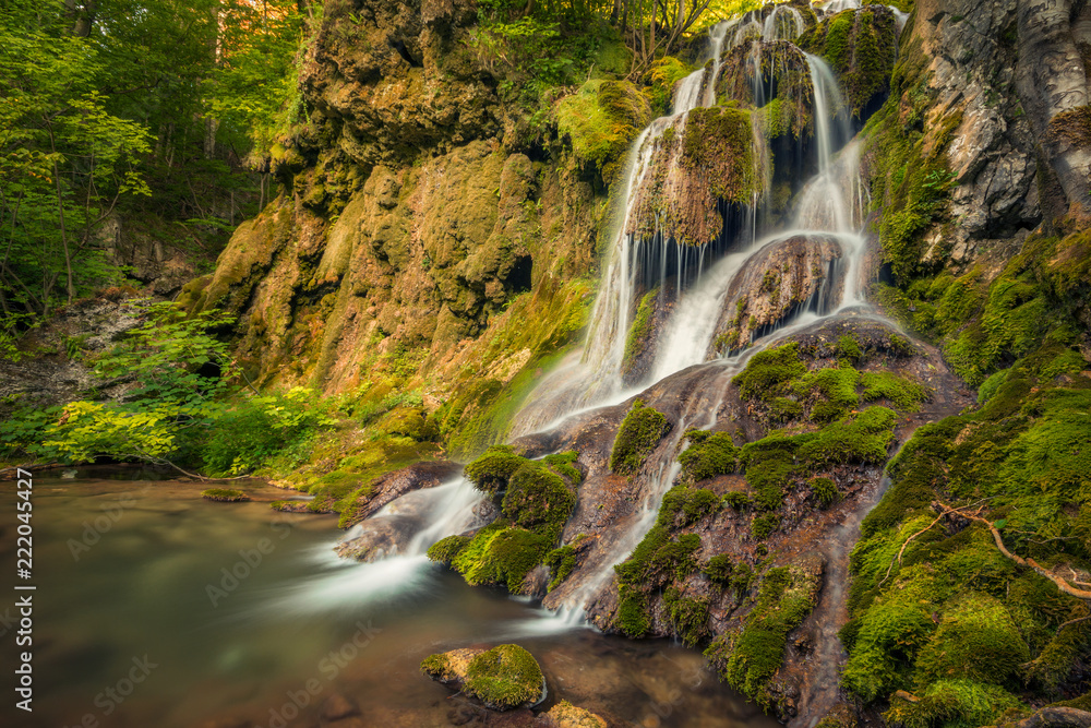 Obraz premium Beautiful waterfall in natural landscape with rocks and moss