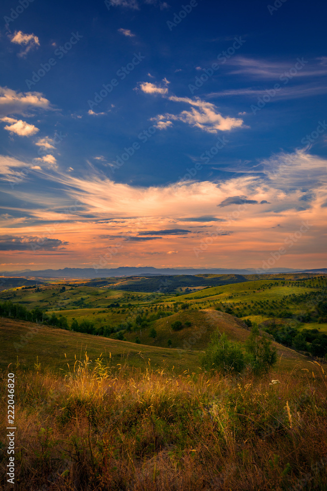 Beautiful view over the picturesque hills with a sky full with beautiful clouds at sunset