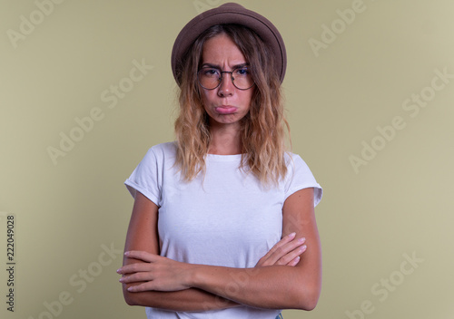 displeased woman in glasses wearing hat photo