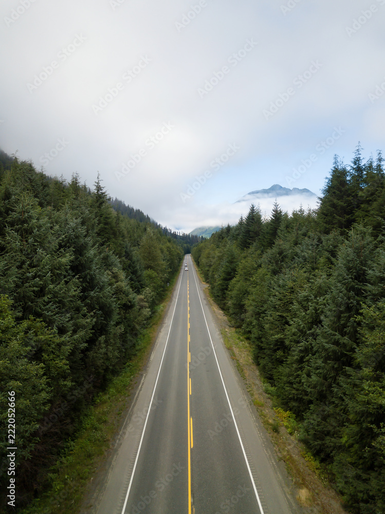 Aerial view of a scenic road in the Canadian Landscape during a vibrant cloudy summer day. Taken in Northern Vancouver Island, BC, Canada. Aerial view of a scenic road in the Canadian Landscape during a vibrant cloudy summer day. Taken in Northern Vancouver Island, BC, Canada.