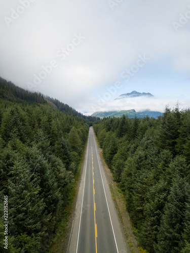 Aerial view of a scenic road in the Canadian Landscape during a vibrant cloudy summer day. Taken in Northern Vancouver Island, BC, Canada.