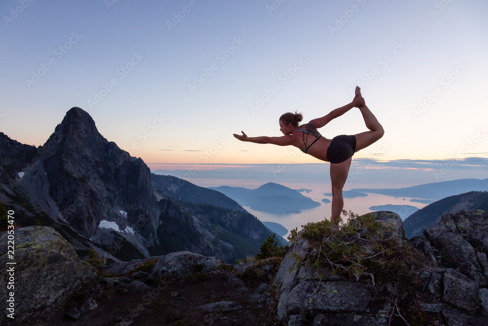 Girl practicing yoga on top of a mountain during a vibrant summer sunset. Taken in Howe Sound, near Vancouver, BC, Canada. Girl practicing yoga on top of a mountain during a vibrant summer sunset. Taken in Howe Sound, near Vancouver, BC, Canada.