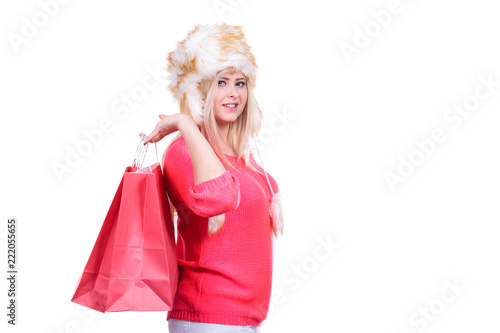Woman in furry winter hat holding shopping bags