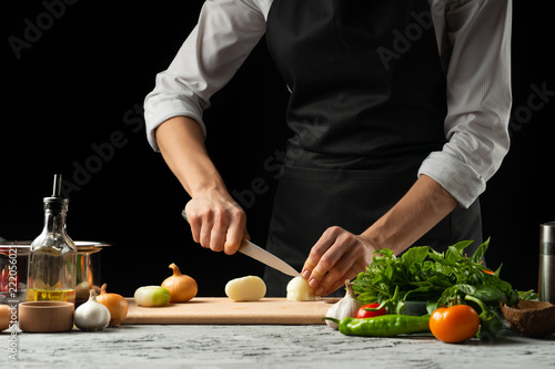 Close the chef's hands, preparing an Italian tomato sauce for macaroni.pizza. The concept of the Italian cooking recipe