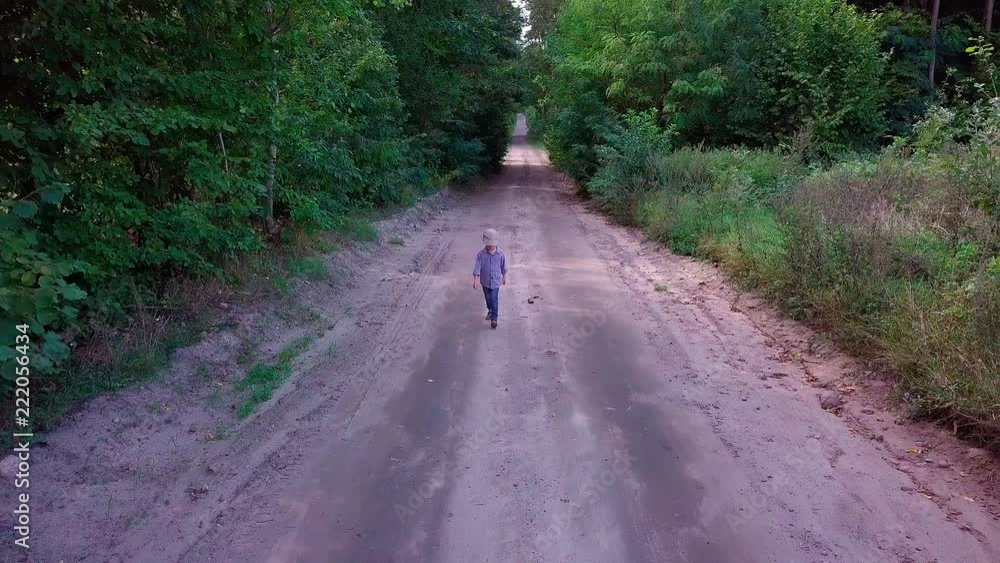 4k AERIAL: small boy running through sandy forest road at late summer sunny afternoon 4k AERIAL: small boy running through sandy forest road at late summer sunny afternoon