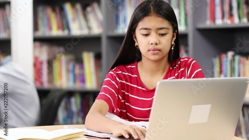 Female High School Student Working At Laptop In Library