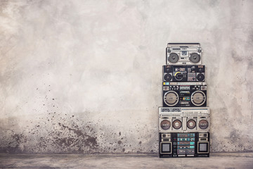 Retro old school design ghetto blaster boombox  stereo radio cassette tape recorders tower from circa 1980s front concrete wall background. Vintage style filtered photo