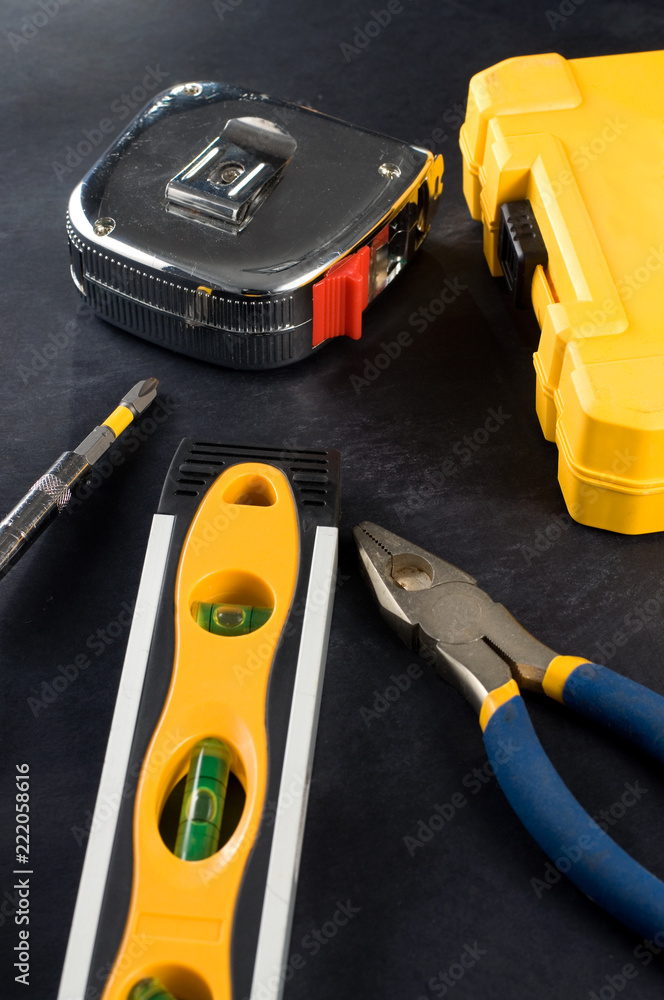 Yellow Tool Box and Tools on Dark Background