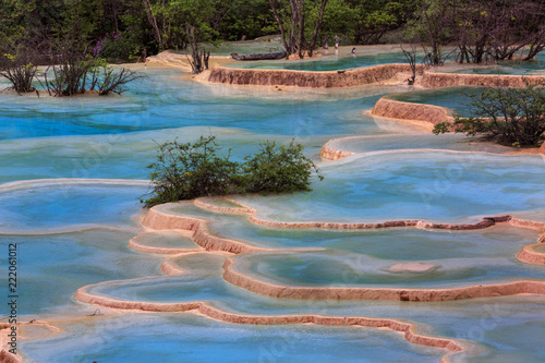 Colorful blue pools of water in Huanglong Scenic Area in Sichuan Province, China. Beautiful and exotic natural geological landforms caused by erosion over time, Chinese yellow dragon natural terraces photo