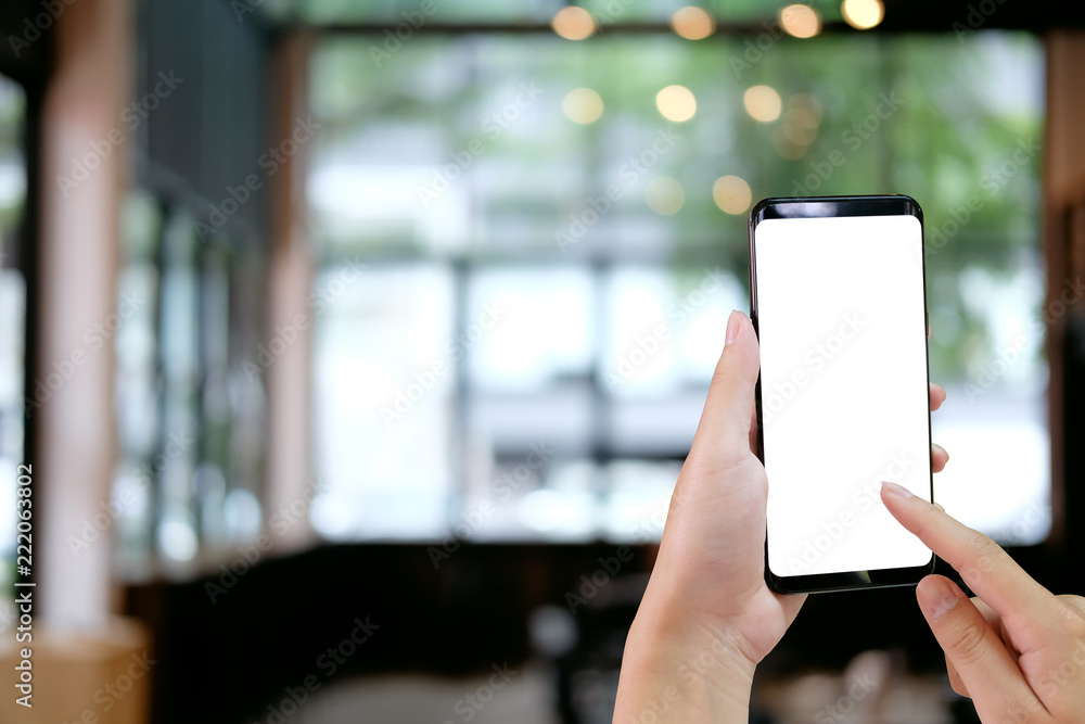 Cropped shot hands touching mockup smartphone on cafe background. Cropped shot hands touching mockup smartphone on cafe background.