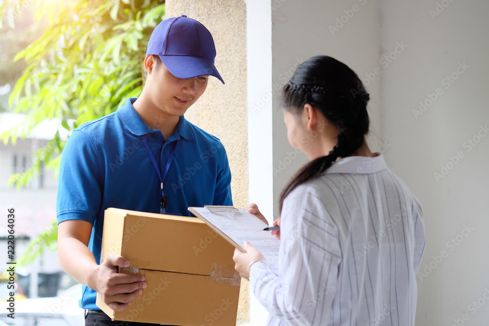 Woman appending signature sign on tablet after accepting receive boxes from delivery man, woman sign on digital tablet, receive delivery concept Woman appending signature sign on tablet after accepting receive boxes from delivery man, woman sign on digital tablet, receive delivery concept