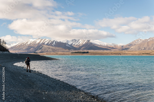 Man taking a photo of mountains at Lake Tekapo © Wade